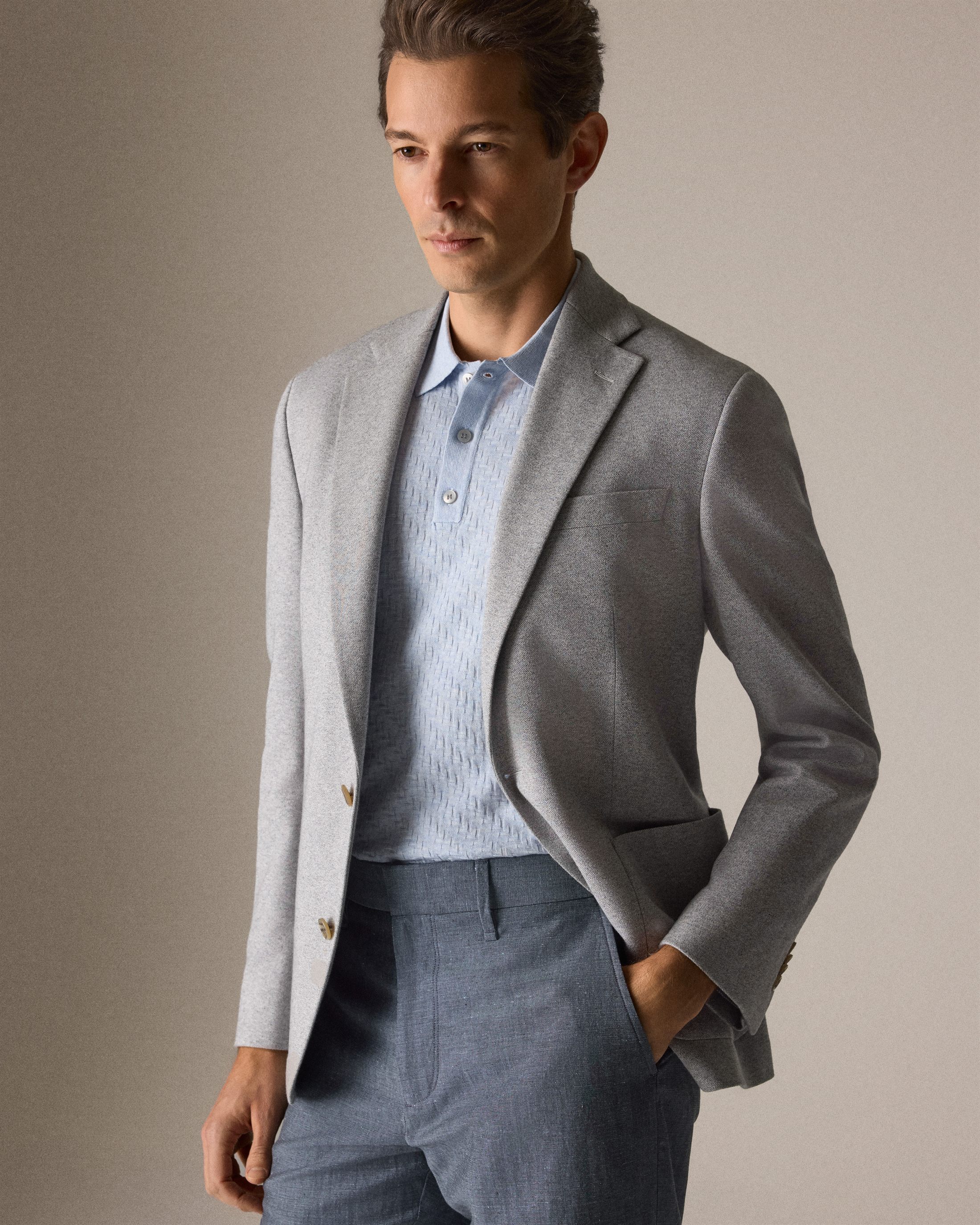 Mannequin portant un veston gris et un polo bleu pâle